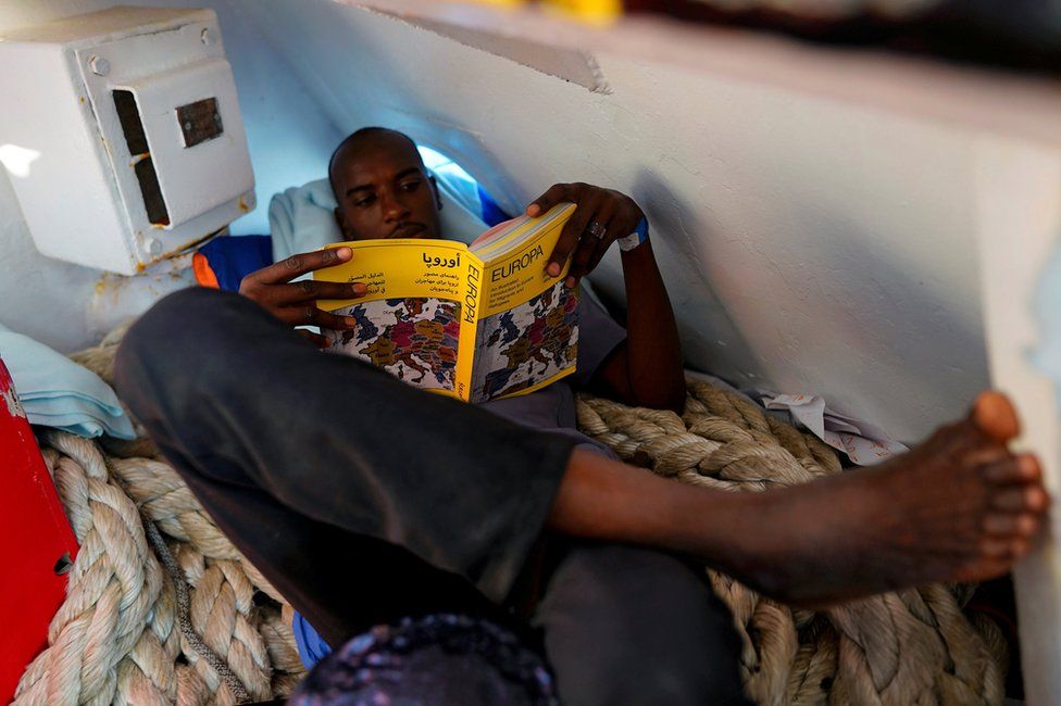 Mohamed, 23, from Sudan, reads a book on board NGO Proactiva Open Arms rescue boat