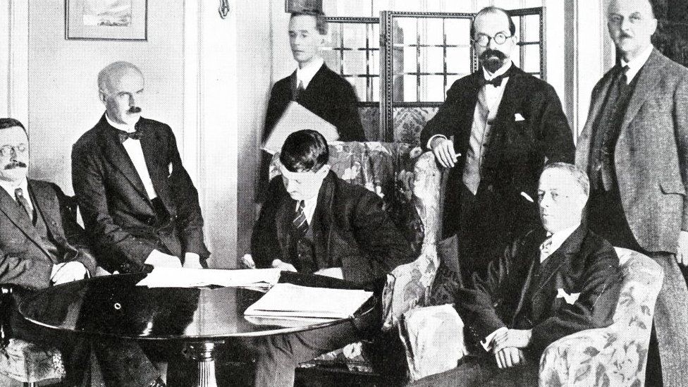 Michael Collins examines the Anglo-Irish Treaty with the other Irish delegates