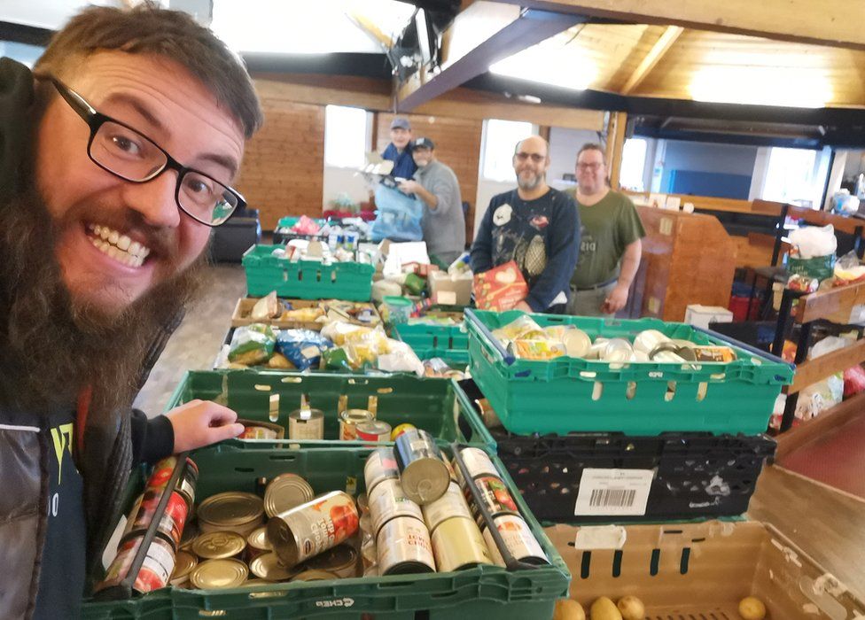 Andru Keel with volunteers by crates of food