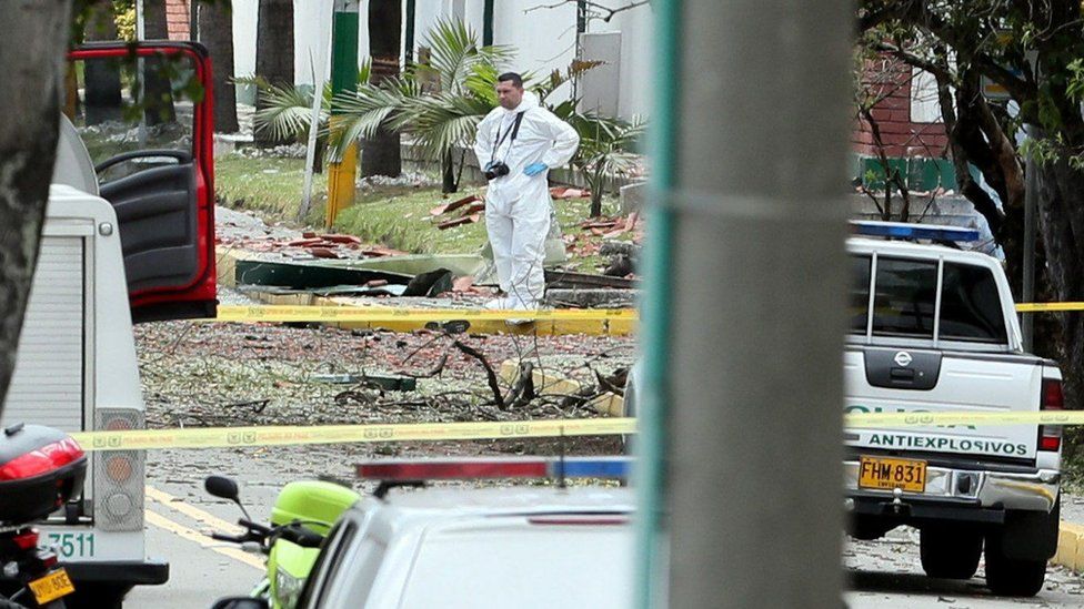 Members of the Colombian Technical Investigation Team (CTI) work at the place where a bomb car caused an explosion