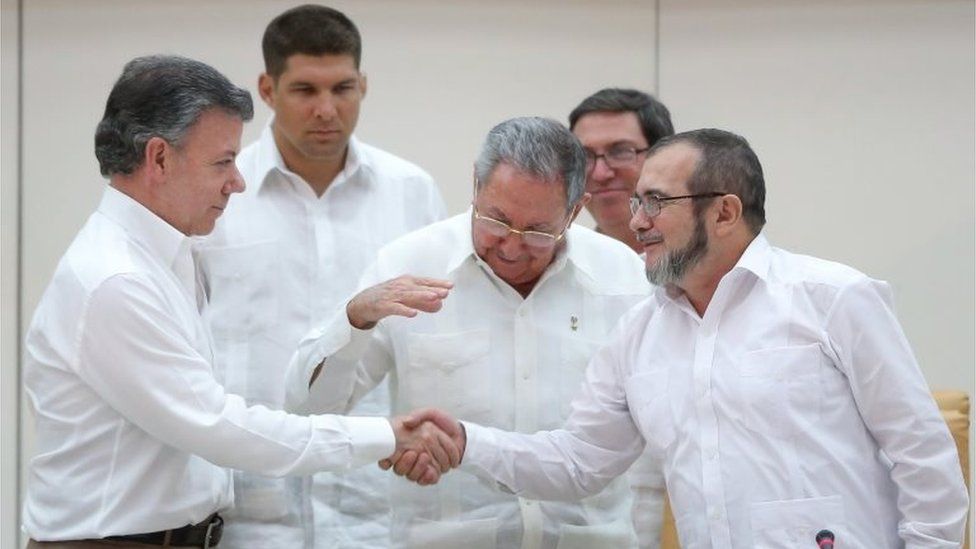 President Raul Castro (centre) reacts as Colombia's President Juan Manuel Santos (left) and Farc rebel leader Rodrigo Londono, better known by the nom de guerre Timochenko, shake hands in Havana on 23 September, 2015