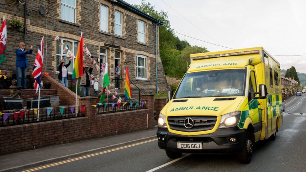 People applauding an ambulance