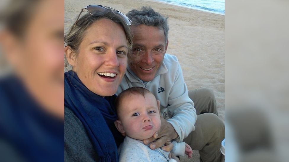 Caroline Coombs and her husband Carlos and son Thomas sitting on the beach
