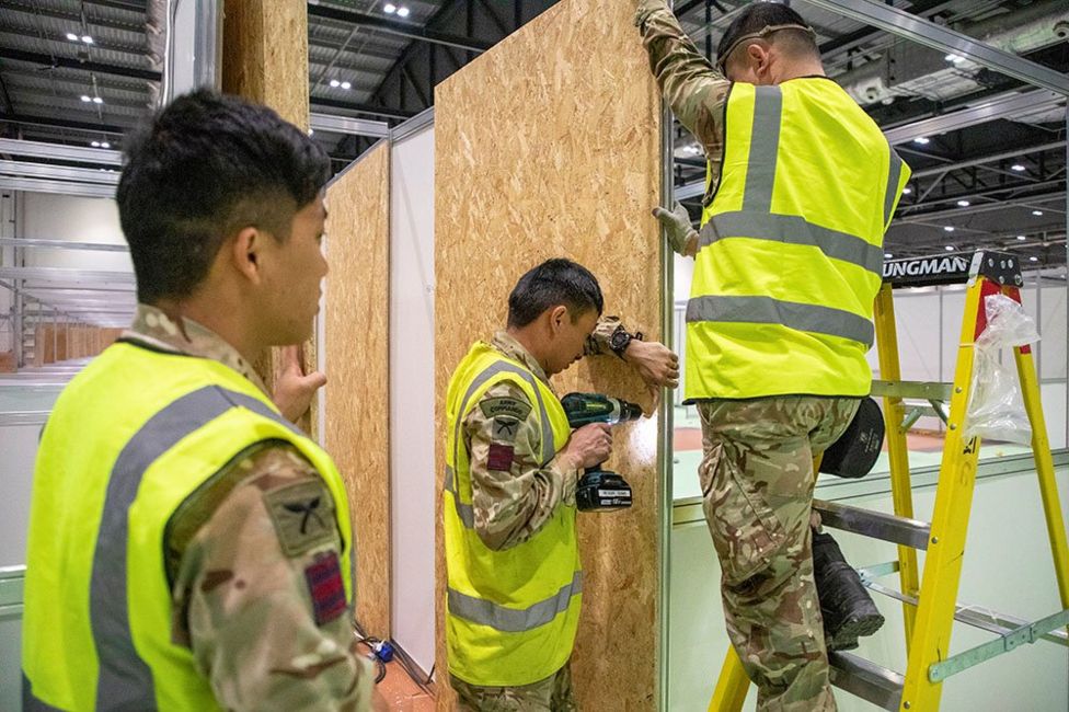 Members of the Queen's Ghurka Engineers Regiment construct cubicles