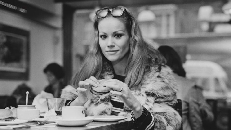 Claudine Auger eating a burger in London in 1968