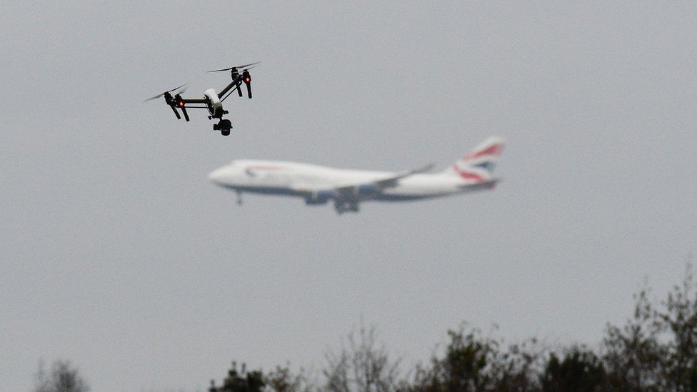 На переднем плане летит дрон, а на заднем плане виден самолет British Airways