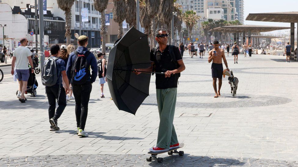 A man rides a skateboard along the beach in Tel Aviv on April 19, 2024