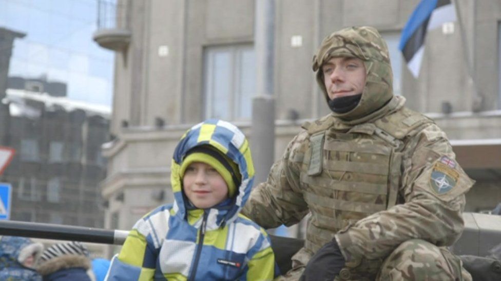Soldier at a parade with an Estonian boy