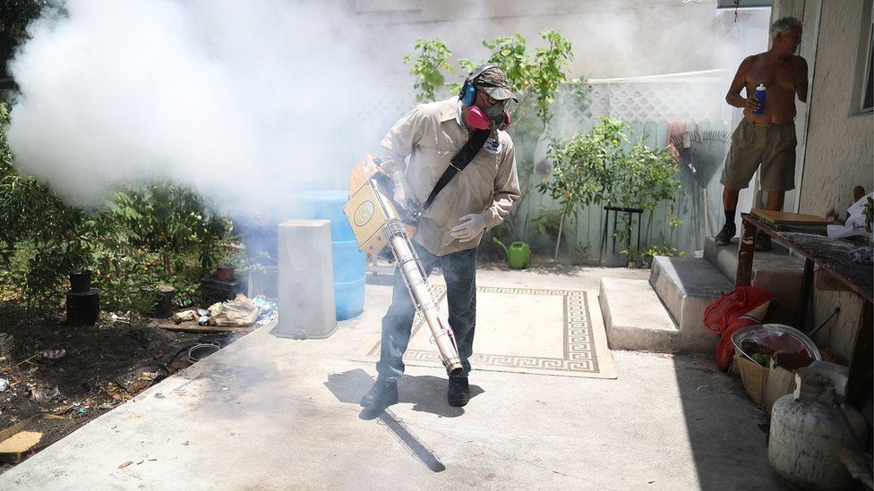 A Miami-Dade County mosquito control inspector fumigates the Wynwood neighbourhood