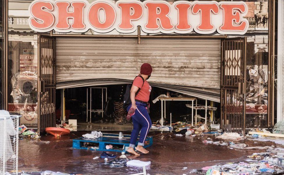 A person walks pass a deserted Dr. Pixley Ka Seme street strewn with dirt and filth caused after five days of looting in Durban on July 14, 2021
