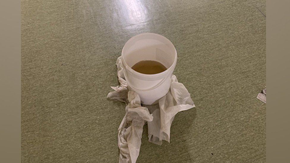 A bucket catches rainfall in hospital corridor at the Queen Elizabeth Hospital, King's Lynn