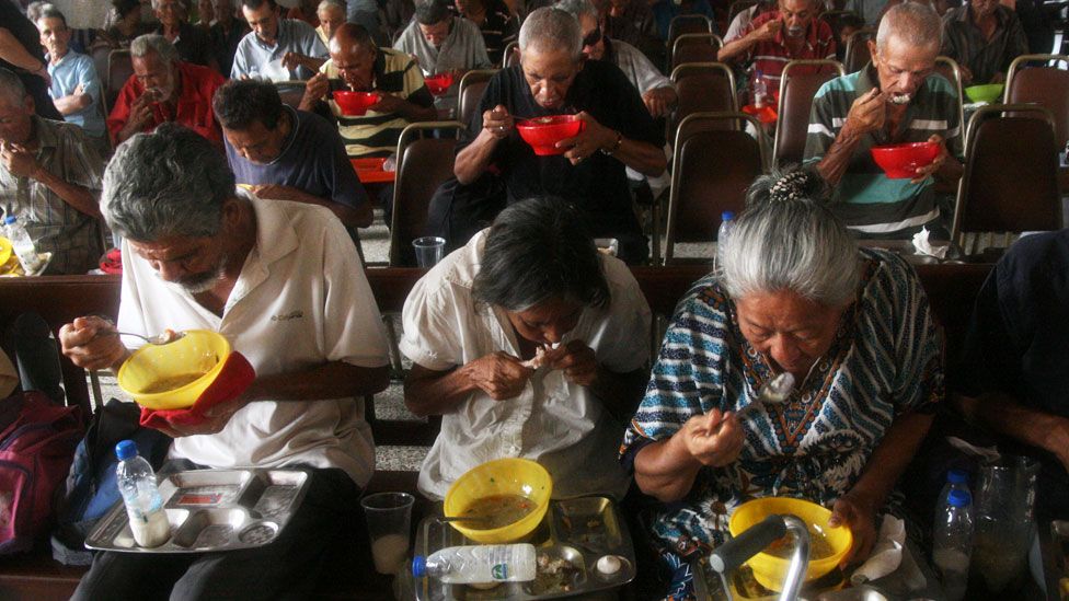 Venezuelans eating food provided by church volunteers