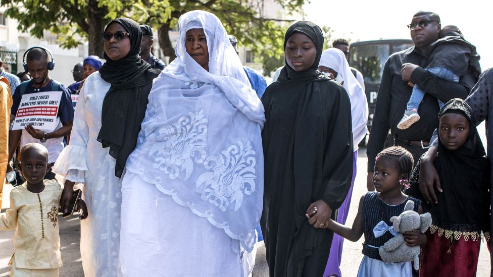 Члены семьи Эбримы Соло Санденга идут за катафалком с его гробом на похоронах в Банжуле, Гамбия, 10 января 2023 г.