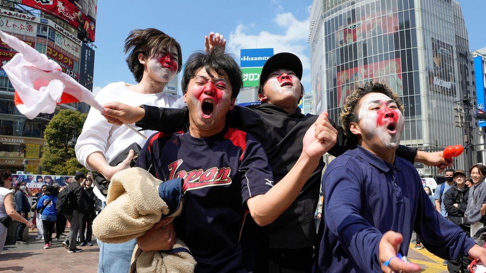 Japan national baseball team members celebrate after beating China