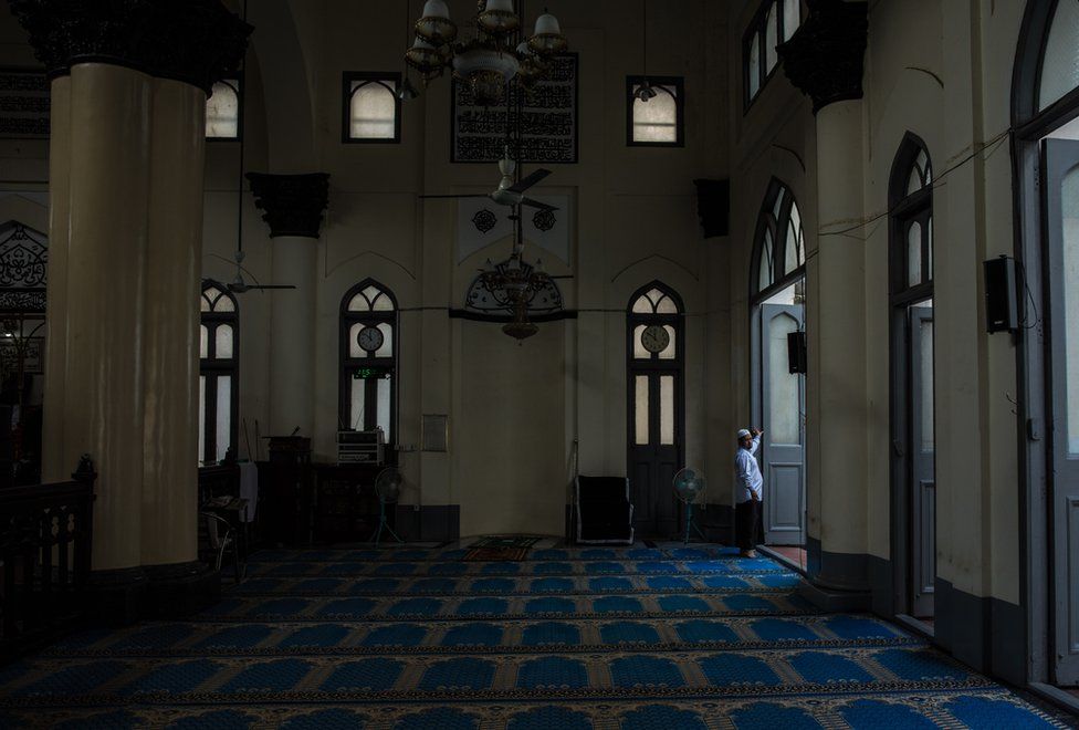 Farooq prepares the prayer room for Zuhr - just after midday - prayer, at the Shia Mughal Mosque in downtown Yangon, Myanmar, November 19, 2015