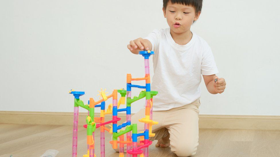 Young boy plays with a marble run