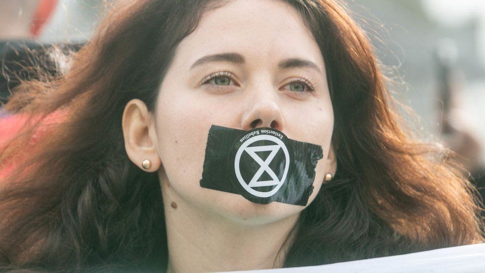 Woman with tape over mouth in protest