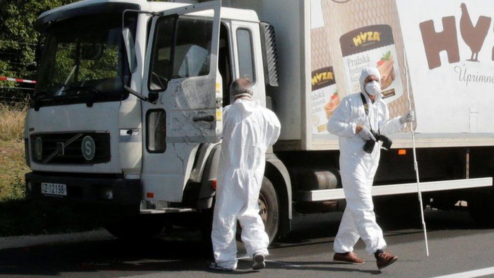Forensic police officers inspect a parked truck in which migrants were found dead, on a motorway near Parndorf, Austria August 27, 2015