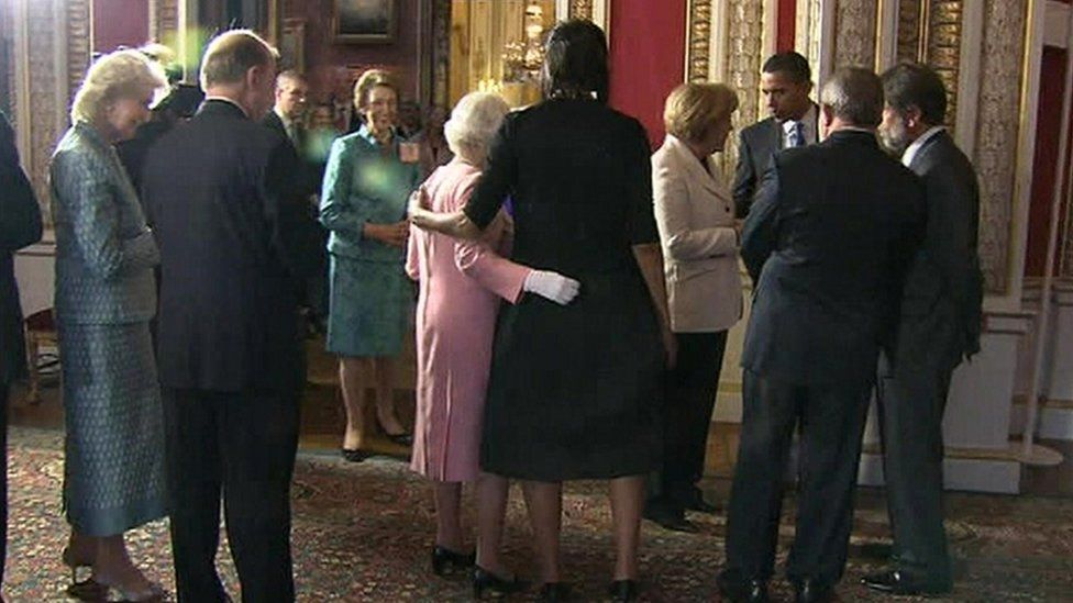 The Queen and Michelle Obama with their arms round each other