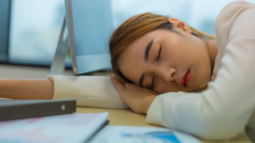A stock image of someone sleeping at work