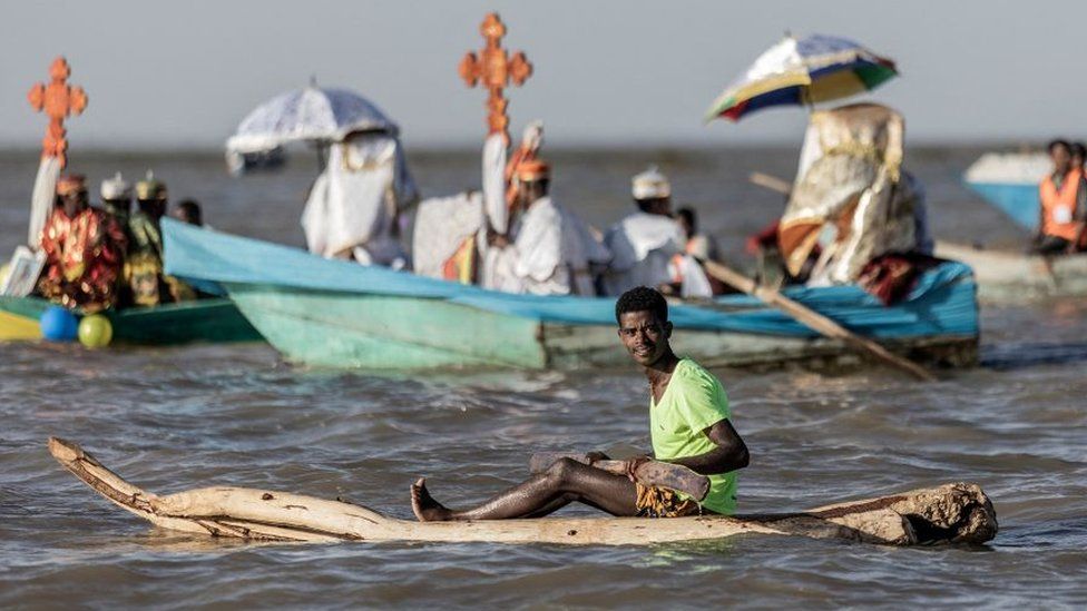 A man rides a boat during the celebration of timkat (The Ethiopian Epiphany) on lake Ziway, also known as lake Dembel, Ethiopia, on January 18, 2023