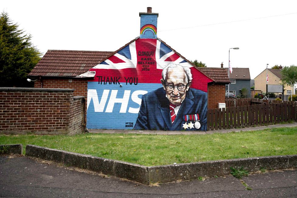 A mural on the side of a house showing Capt Sir Tom Moore with the NHS logo