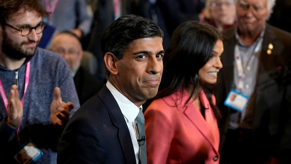 Prime Minister Rishi Sunak and his wife Akshata Murty react as they leave following his speech during the final day of the Conservative Party Conference on on 4 October 2023 in Manchester, England