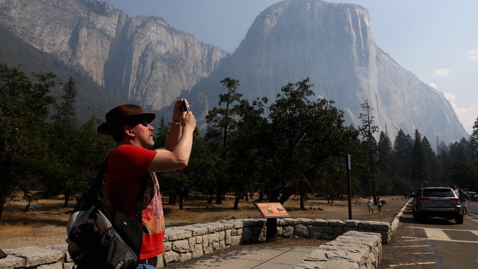 A man takes pictures near El Capitan in the Yosemite Valley Tuesday, August 14, 2018