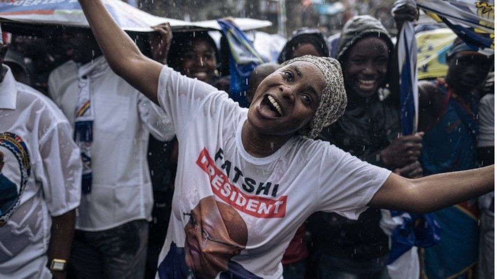 Supporters of the incumbent president President Felix Tshisekedi gesture in the rain prior to his arrival for a campaign rally in Goma, capital of North Kivu province, eastern Democratic Republic of Congo, on December 10, 2023.