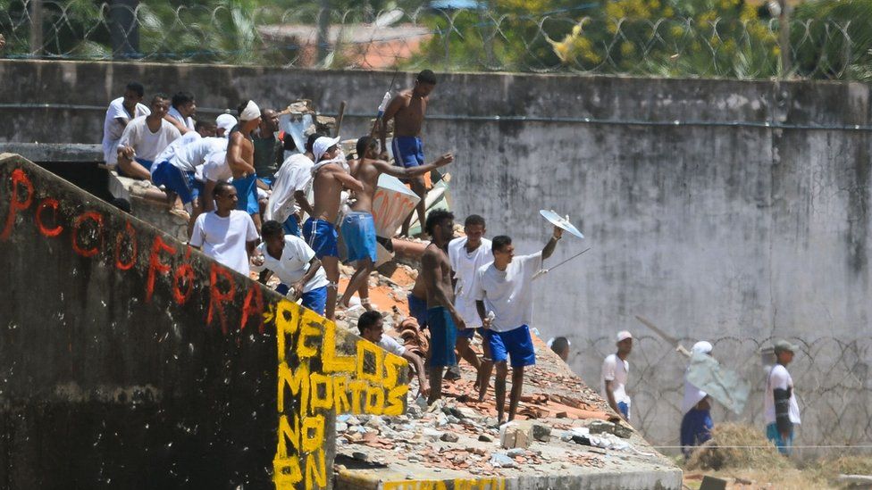 Заключенные остаются на крыше тюрьмы во время беспорядков в тюрьме Алькакуз, недалеко от Натала в Риу-Гранди-ду-Норти, Бразилия, 19 января