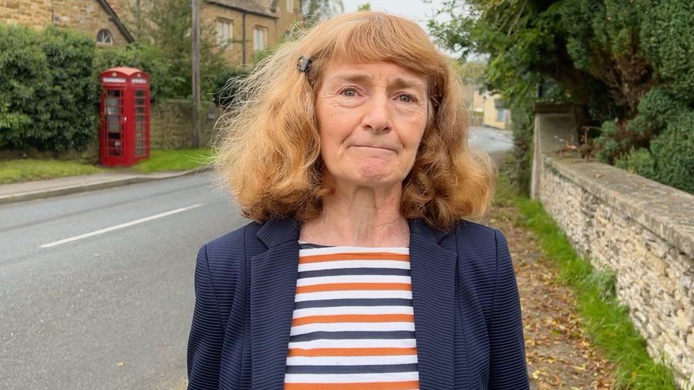 Kath Hudson standing on a road in her village