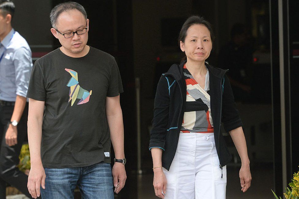 Trader Lim Choon Hong (L) and his wife, Chong Sui Foon (R), both 47, leave the state court in Singapore on March 23, 2016.