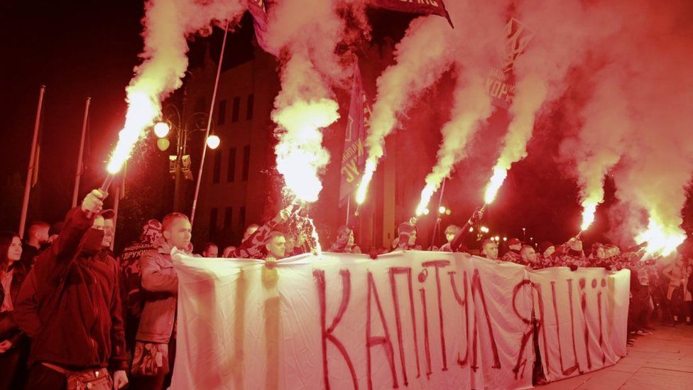 Ukrainian nationalists burn flares and hold banner reading No to capitulation on 1 October