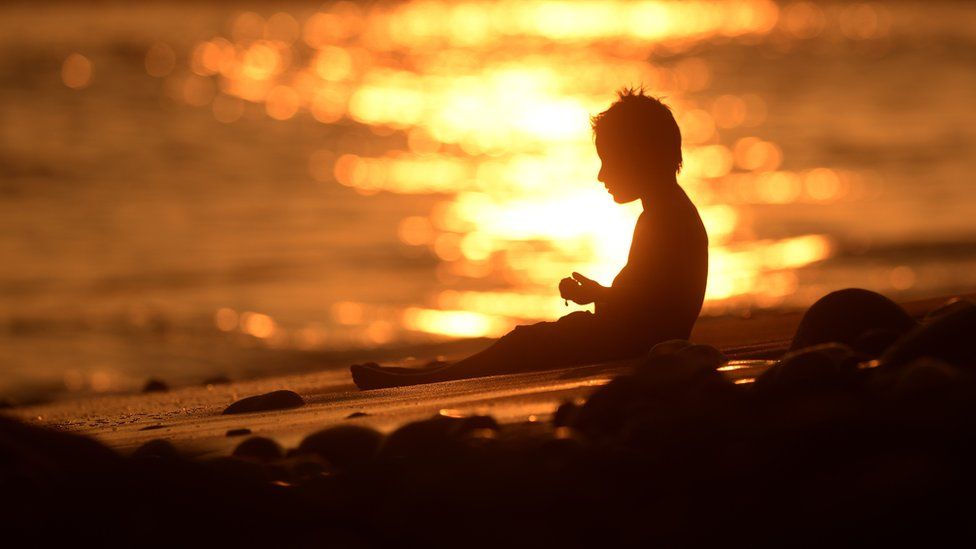 Child on a beach at sunset