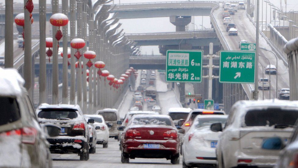 Vehicles on a snow-covered road in Urumqi, capital of China's Xinjiang region