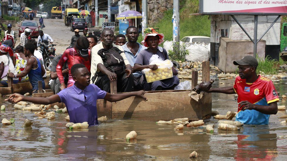 Residents in Kinshasa use a canoe on the city's flooded roads