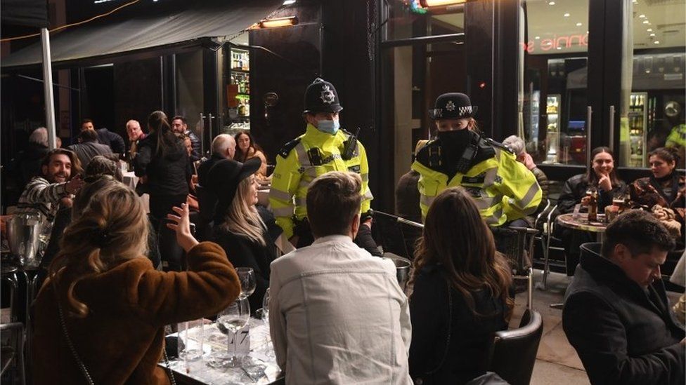 People drink and eat outside in Soho in London
