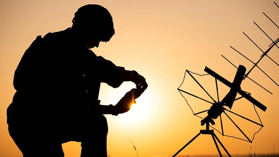 The silhouette of a Dutch commando with the sun in the background