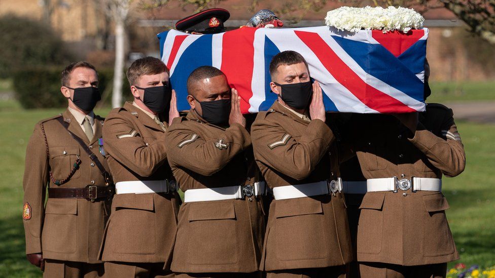 The coffin of Captain Sir Tom Moore is carried by members of the armed forces during his funeral at Bedford Crematorium
