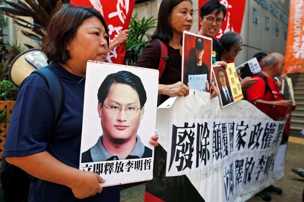 Pro-democracy protesters carry a photo of detained Taiwanese rights activist Lee Ming-Che (L) and other activists during a demonstration in Hong Kong, China 11 September 2017