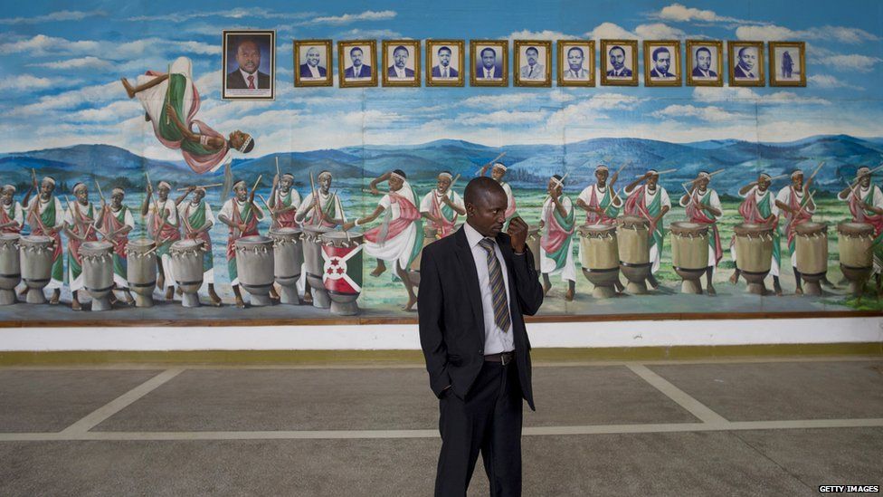 A man stands in front of a painted mural with drummers and dancers and portraits of Burundi's presidents past and present, in the National Assembly in Bujumbura, ahead of the opening session of the National Assembly in Bujumbura, on 27 July 2015