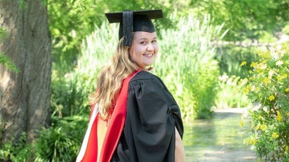 Jennifer in her graduation gown before she begins her Masters degree