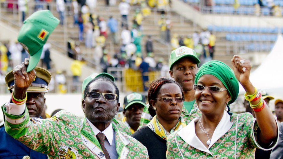 Zimbabwe's President Robert Mugabe (L) and his wife Grace (R) greet supporters after his address at a rally in Harare on July 28, 2013, ahead of elections on July 31.
