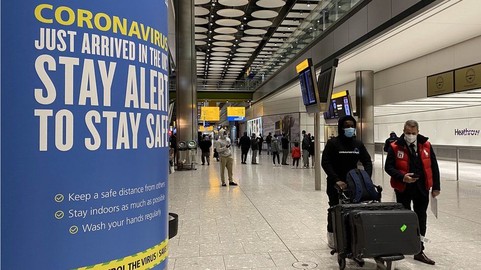 A passenger pushes a trolley through the Arrival Hall of Terminal 5 at London's Heathrow Airport