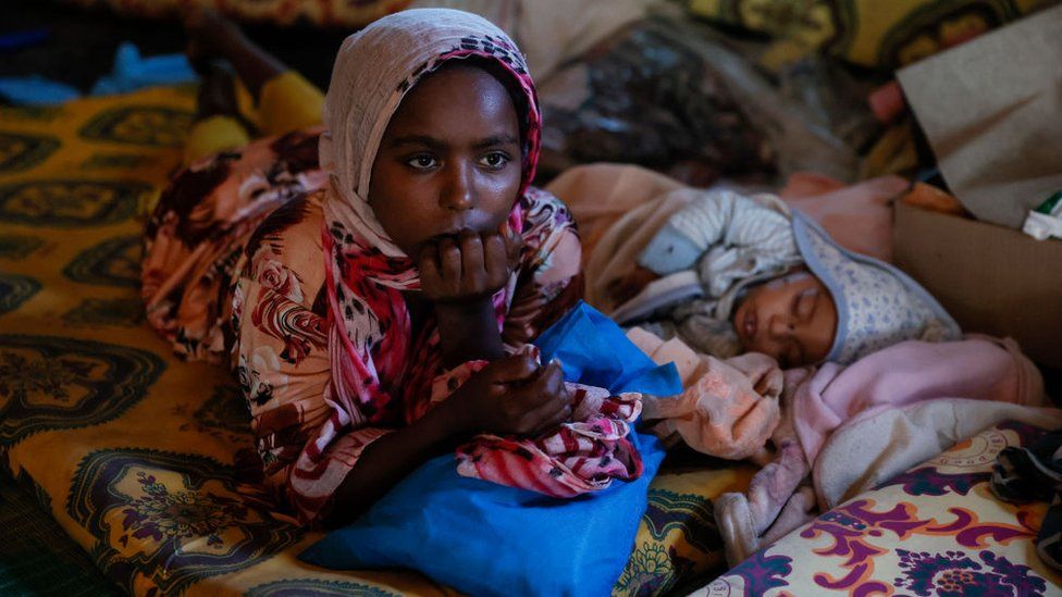 A girl and a child lie on mattresses in a tent erected at the Children's Growing Center on March 28, 2022 in Hayk, Ethiopia. The IDP camp houses over 1,300 ethnic Amhara who had been displaced by ongoing attacks and ethnic cleansing in the province of Wollega in Oromia by the Oromo Liberation Army and Oromo Liberation Front. The attacks against ethnic Amhara farmers and business people who had lived in the region for at least 2 generations or more are meant to rid the Oromia region of ethnic amhara and forcibly acquire their lands and property