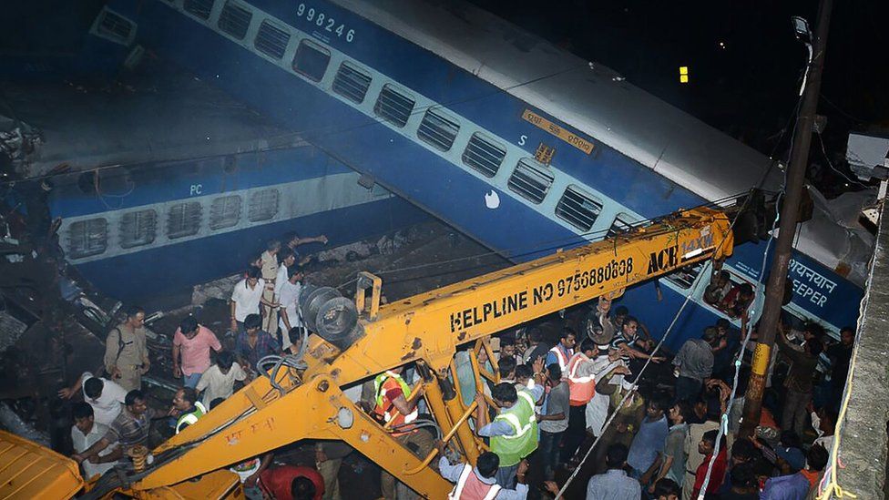 Emergency workers look for survivors on the wreckage of a train carriage after a train derailed in the Indian state of Uttar Pradesh on August 19, 2017