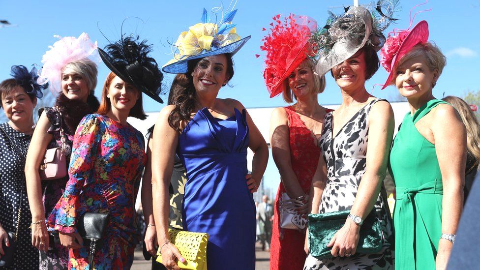 Women pose for photos on Ladies Day at Aintree