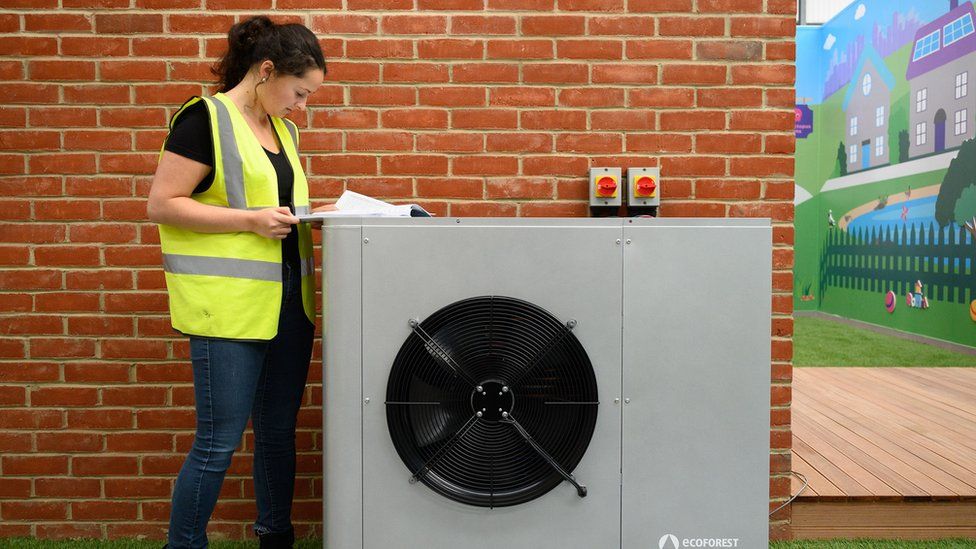 A project engineer checks the paperwork for the installation of a Daikin 7KW heat pump on a model house within the Octopus Energy training facility on November 02, 2021 in Slough, England.