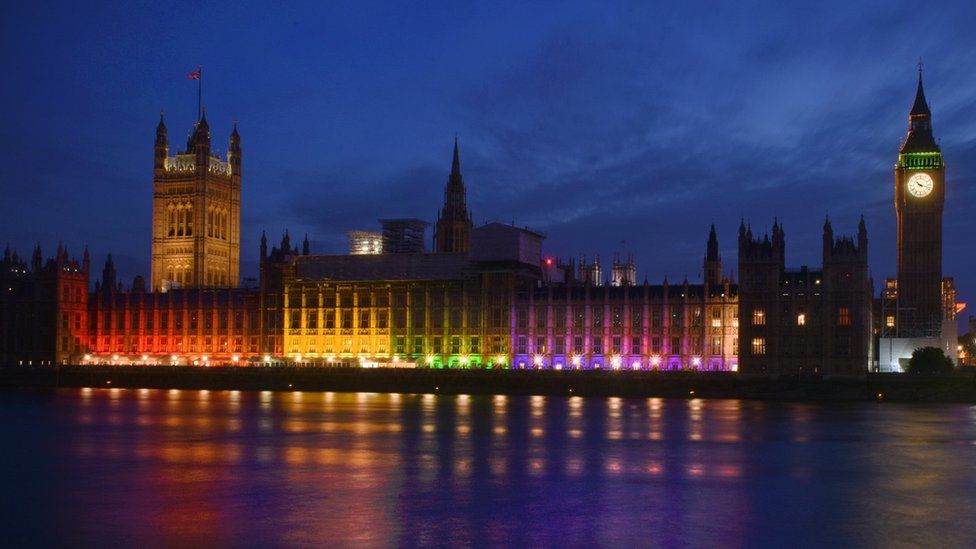 Houses of Parliament lit up with the rainbow flag