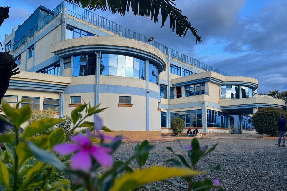 A curved white building with blue trim